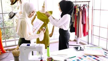 mulheres muçulmanas felizes trabalhando juntas no escritório de roupas. foto