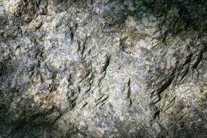 fundo de textura de rocha de granito cru. fragmento de parede de pedra natural. foto