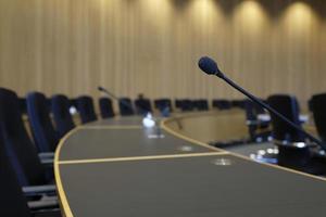 sala de conferências com paredes de madeira e microfones em cada assento foto