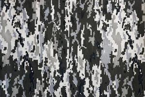 tecido com textura de camuflagem pixelizada militar ucraniana. pano com padrão de camuflagem em formas de pixel cinza, marrom e verde. uniforme oficial de soldados ucranianos foto