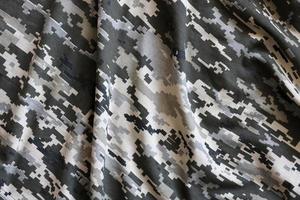 tecido com textura de camuflagem pixelizada militar ucraniana. pano com padrão de camuflagem em formas de pixel cinza, marrom e verde. uniforme oficial de soldados ucranianos foto