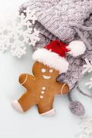 homem de gengibre, biscoitos e decoração de natal em fundo pastel. foto