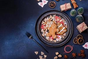 decorações de natal e pães de gengibre em uma mesa de concreto escuro. preparando e decorando a casa para o feriado foto