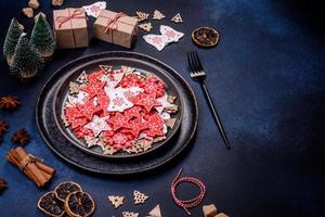 decorações de natal e pães de gengibre em uma mesa de concreto escuro. preparando e decorando a casa para o feriado foto