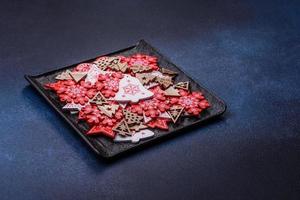 decorações de natal e pães de gengibre em uma mesa de concreto escuro. preparando-se para a celebração foto