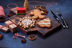 elementos de decorações de natal, doces e pão de gengibre em uma tábua de madeira foto