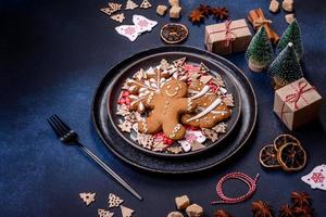 decorações de natal e pães de gengibre em uma mesa de concreto escuro. preparando e decorando a casa para o feriado foto