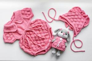 lindas roupas de malha de bebê e um brinquedo para um bebê recém-nascido foto