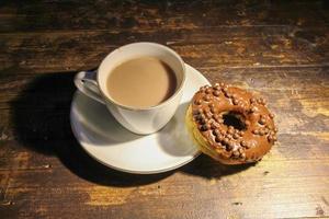 rosquinha de chocolate e uma xícara de leite com chocolate foto