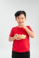 menino comendo um bebê de geléia de uma tigela de doces de pirulitos coloridos misturados. foto