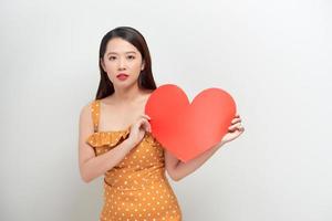 retrato de mulher sorridente atraente segurando coração vermelho sobre fundo branco foto