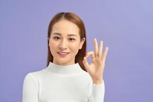 linda jovem mostrando os polegares para cima gesto, isolado no fundo violeta foto