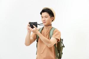 viajante e fotógrafo. retrato de estúdio de jovem bonito segurando photocamera tirando foto. foto