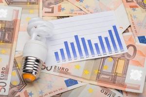 lâmpada de poupança de energia e gráfico nas notas de euro foto