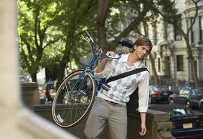 empresário carregando bicicleta ao ar livre