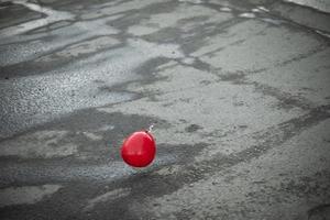 bola vermelha voa sobre o asfalto. balão lá fora. foto