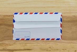envelope por correio aéreo isolado na madeira foto