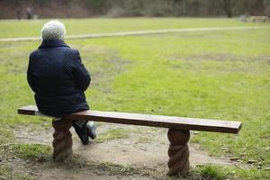 mulher senta-se no banco no parque. pensionista na rússia repousa no parque. foto