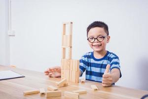 menino asiático brincando com um quebra-cabeça de madeira foto