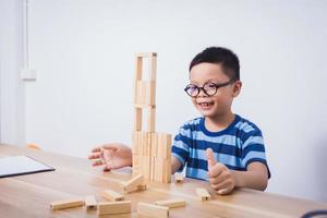 menino asiático brincando com um quebra-cabeça de madeira foto