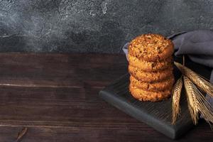 biscoitos caseiros com cereais e sementes. biscoitos de aveia em um fundo de madeira. copie o espaço. foto