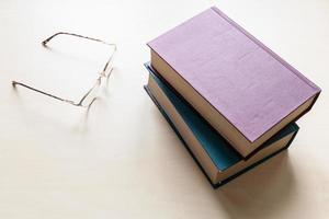 óculos e dois livros em branco na placa de luz