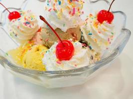 bolas de sorvete com chantilly e cereja foto