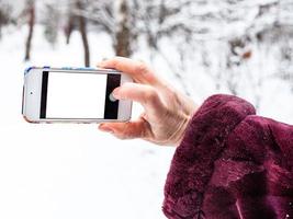 mão feminina tira foto por smartphone no inverno