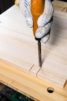 carpinteiro usando cinzel corta sulco na placa de madeira foto