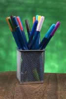 criatividade de caneta colorida colorida em estojo com espaço de cópia em fundo verde bokeh turva foto