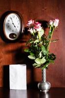 relógio de parede, folha de papel em branco e rosas cor de rosa foto
