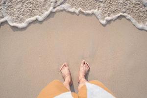 jovem viajante e onda do mar suave na praia tropical no verão foto