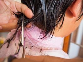 cabeleireiro cortando cabelo no salão de beleza foto