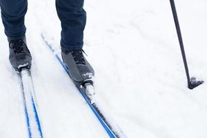 pés de um esquiador em botas de esqui em esquis cross-country. andando na neve, esportes de inverno, estilo de vida saudável. close-up, copyspace foto