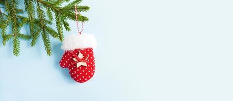 decoração de natal de luva de malha vermelha em um galho de abeto verde em um fundo branco. quadro, copie o espaço. natal ano novo, árvore de natal. manter aquecido no inverno foto