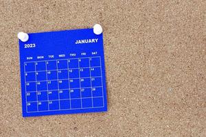 calendário azul de janeiro de 2023 com pino no outdoor de boletim de cortiça. foto