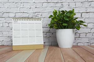 Calendário 2022 com vaso de plantas na mesa de madeira. conceito de ano novo. foto