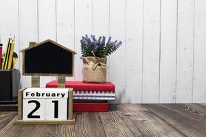 21 de fevereiro texto de data de calendário no bloco de madeira com artigos de papelaria na mesa de madeira. foto