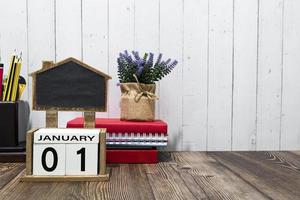 01 de janeiro data do calendário texto no bloco de madeira branco uma mesa. foto