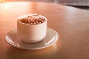 xícara de café quente na mesa de madeira foto