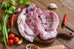 alecrim de carne de porco crua de porco fresco na chapa branca com ervas e especiarias tomate legumes