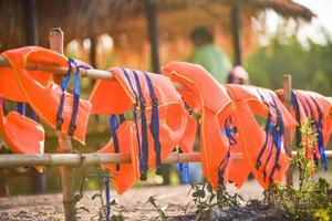 equipamento de segurança de colete salva-vidas colorido no trilho de bambu foto