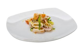 salada asiática de frutos do mar no prato e fundo branco foto