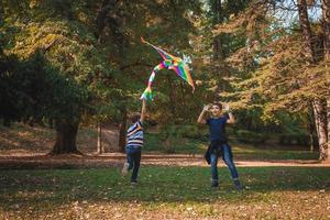 meninos felizes se divertindo com uma pipa na natureza. foto