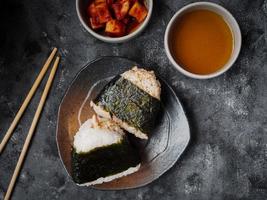 onigiri comida tradicional japonesa, arroz cozido no vapor em forma de triângulo envoltório com algas marinhas. foto