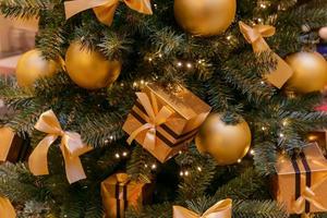 fundo de férias de natal e ano novo. árvore de natal decorada com bolas douradas e caixas de presente. conceito de celebração foto