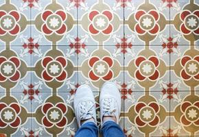 selfie de vista superior dos pés em sapatos de tênis no fundo do piso vintage sem costura com espaço de cópia foto