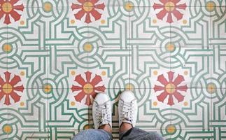 selfie de vista superior dos pés em sapatos de tênis no fundo do piso vintage sem costura com espaço de cópia foto