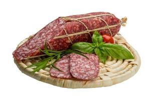 salame na placa de madeira e fundo branco foto