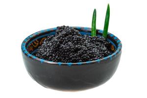 caviar preto em uma tigela no fundo branco foto